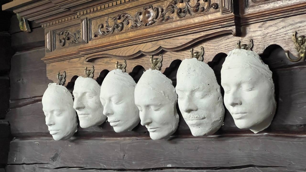 Гіпсові зліпки облич на різьбленій полиці